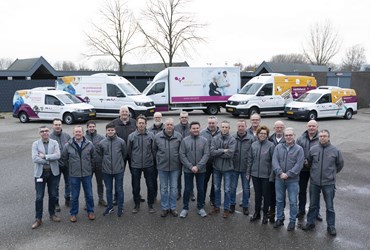 Een groepsfoto van team Wegtransport. Ze staan voor de nieuwe bestelwagens.