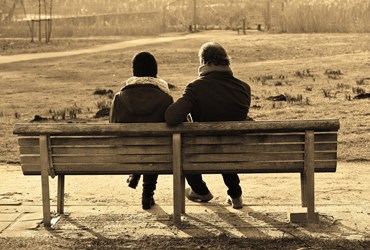 Twee mensen zitten naast elkaar op een bankje