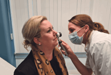Arts controleert gezicht van een patiënt.