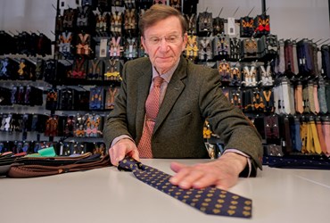 Op deze foto ziet u meneer Rooymans aan het werk in de winkel van zijn kinderen. Hij is stropdassenfabrikant. 