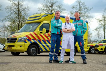 D.G. Barten voor ambulance met collegas