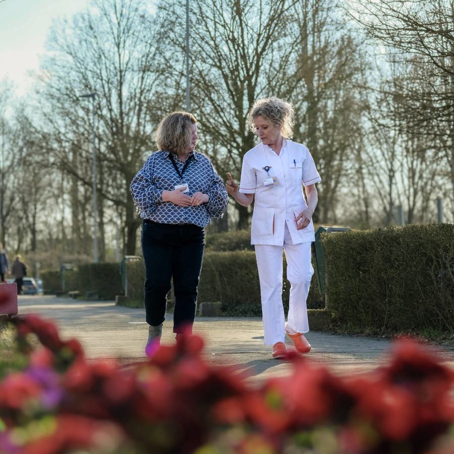 Zorgverlener wandelt met patiënt