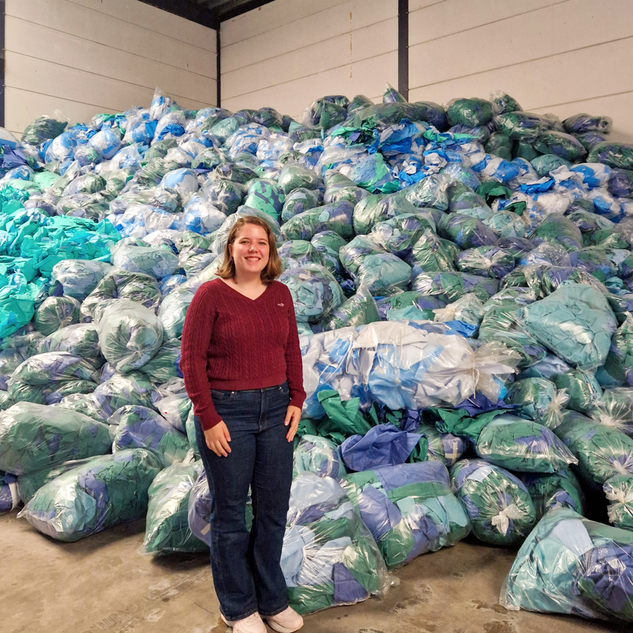 Isabella Klarenbeek, onderzoeker duurzaamheid staat bij een berg vuilniszakken