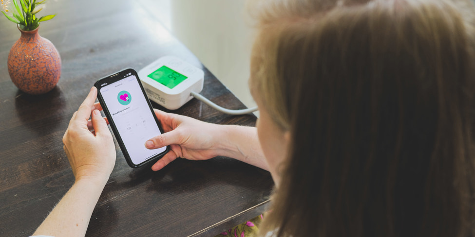 Een patient meet aar bloeddruk en geeft dit met een app door aan het Monitoringscentrum van VieCuri