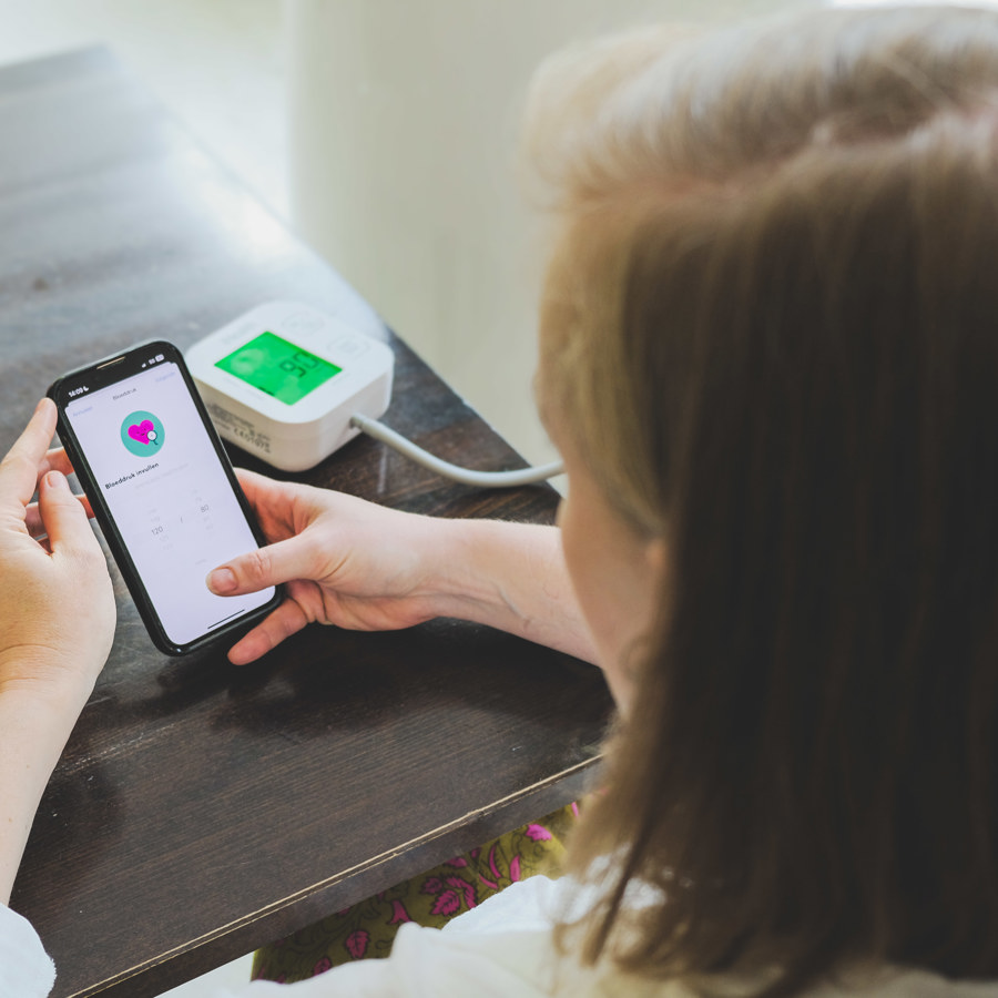 Een patient meet aar bloeddruk en geeft dit met een app door aan het Monitoringscentrum van VieCuri
