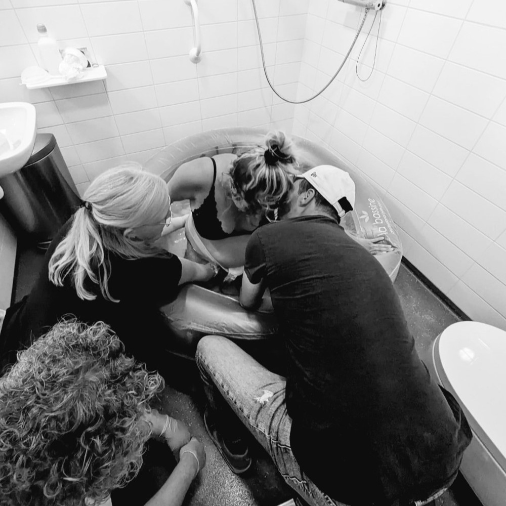 Bevallen in bad met ondersteuning van partner en verloskundige