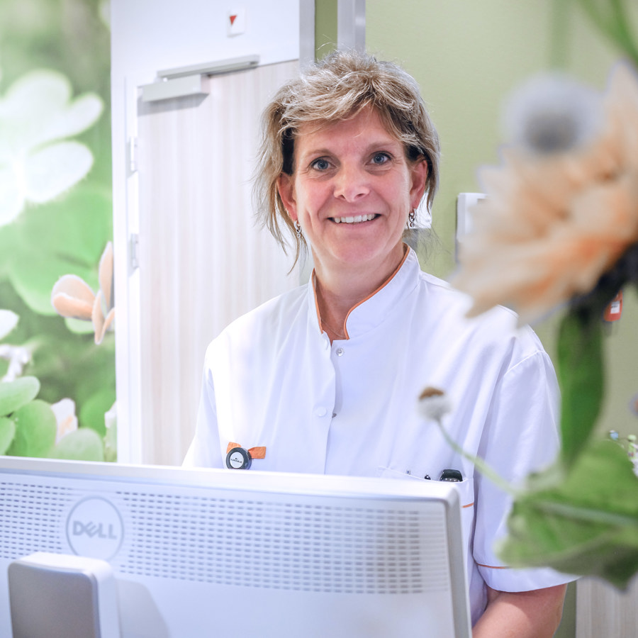 Secretaresse bij Radiologie ontvangt een patiënt aan de balie Secretaresse bij Radiologie ontvangt een patiënt aan de balie