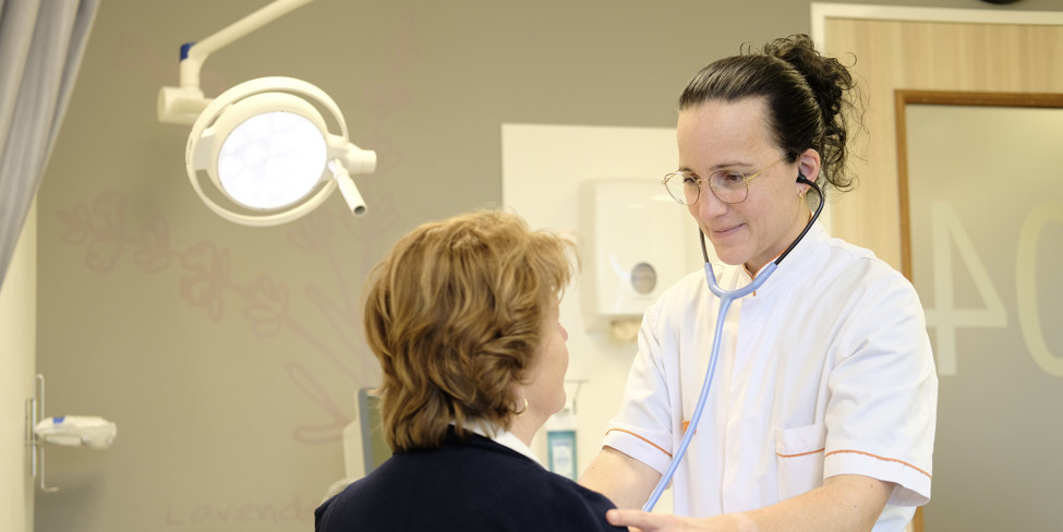 Monique Meijers-Dohmen, Physician Assistent Interne Geneeskunde staat bij een patiënt 