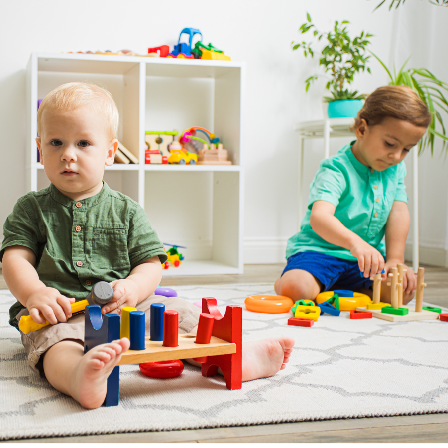Baby en peuter aan het spelen met blokken.