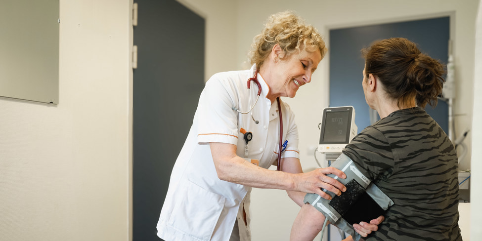 Dokter doet een bloeddrukmeting bij de patiënt