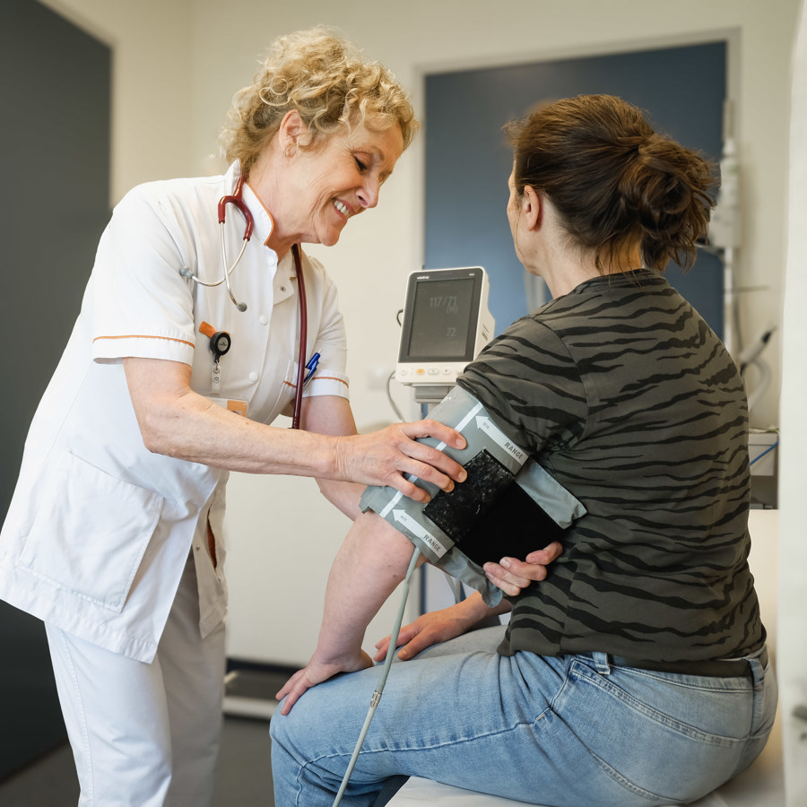 Dokter doet een bloeddrukmeting bij de patiënt