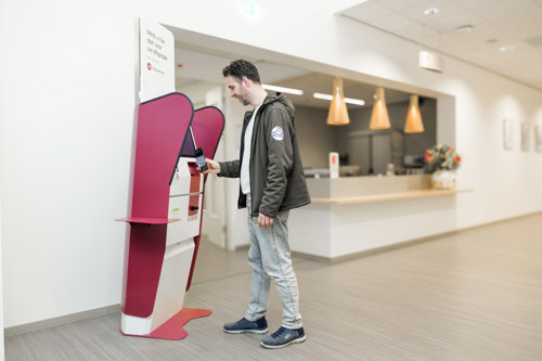 Patiënt scant QR-code op telefoon op zuil