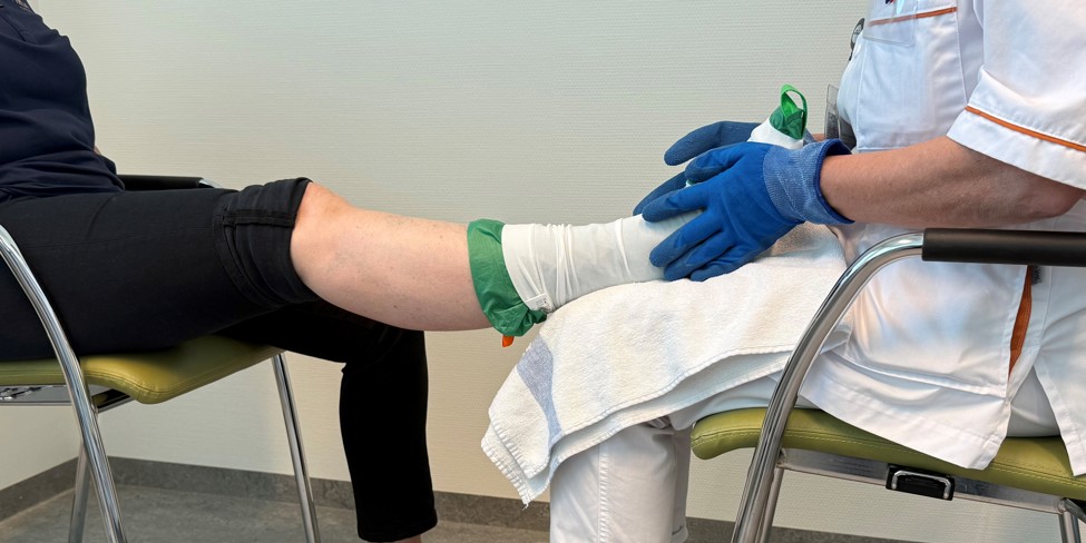 Patiënt leert steunkousen aan te trekken