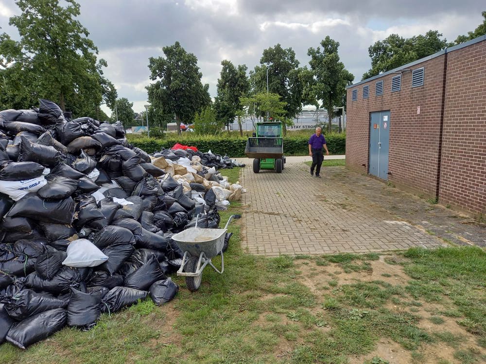 Hoogwater 2021, een berg met zandzakken 