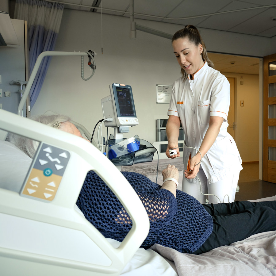 verpleegkundige aan het bed van patiënt