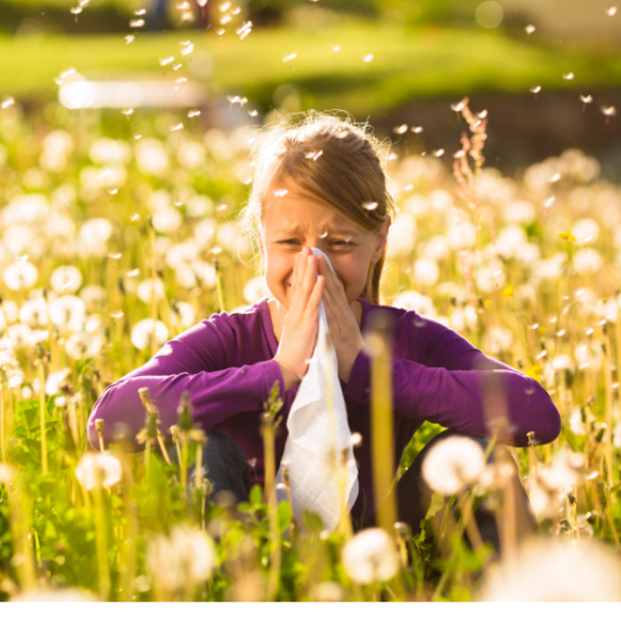 Kind niezend in gras met zakdoek Kind niezend in gras met zakdoek
