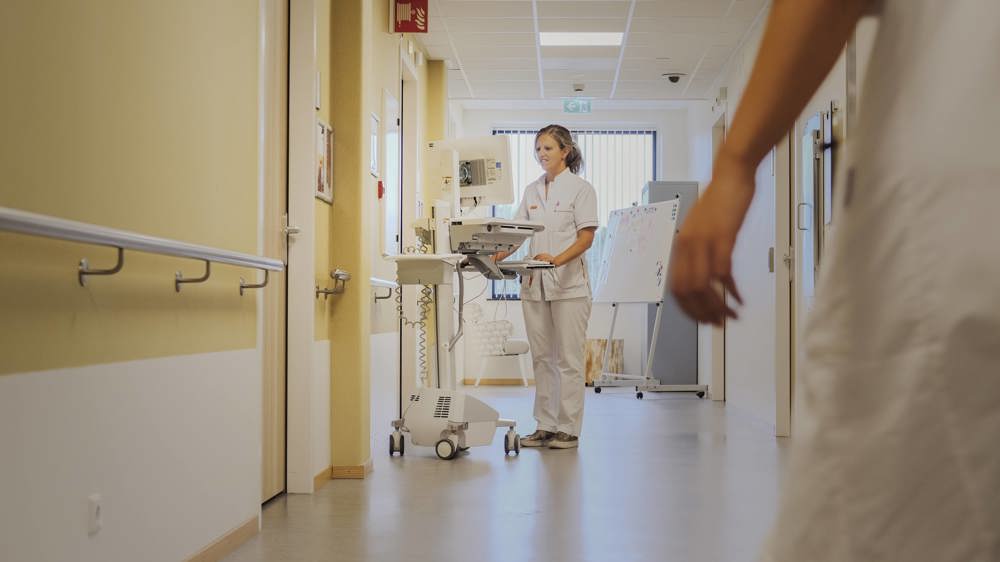 Verpleegkundige op de gang van afdeling Neonatologie/ Couveusesuite.