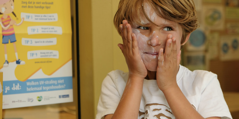 Jongen smeert zich in met zonnebrnadcreme