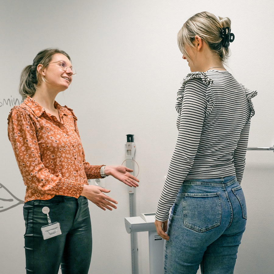 diëtiste in gesprek met patiënt bij weegschaal diëtiste in gesprek met patiënt bij weegschaal