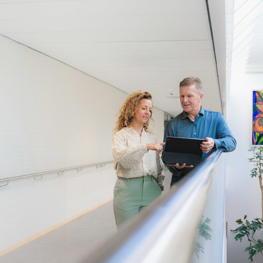 VieCuri collega's Lottie en Wilfred in de gang bij VieCuri met een laptop