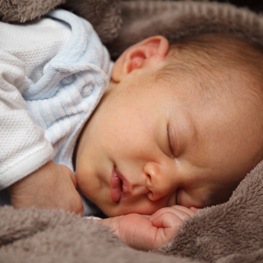 Baby slaapt, bruine deken