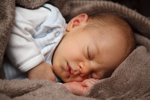 Baby slaapt, bruine deken