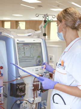Dialyseverpleegkundige controleert gegevens op dialyseapparaat