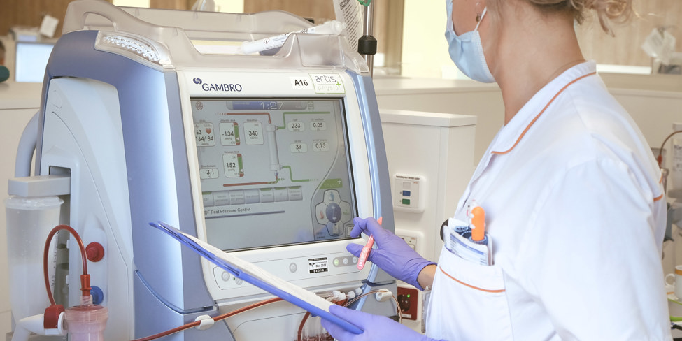 Dialyseverpleegkundige controleert gegevens op dialyseapparaat