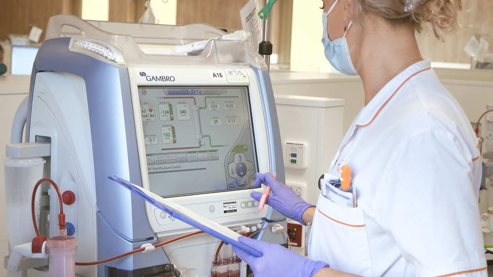 Dialyseverpleegkundige controleert gegevens op dialyseapparaat