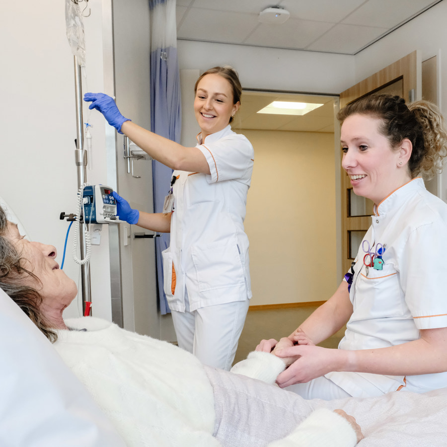 Oncologieverpleegkundigen Sharona (staand) en Britt (zittend) maken het patiënt Dorien Schatorie-Gielen comfortabel op de Fast Track Oncocare. Dorien: 'De rust op een verpleegafdeling maakt zo'n verschil voor mij.'