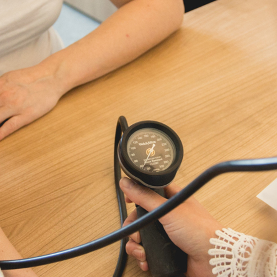 Iemand meet de bloeddruk van een patiënt Iemand meet de bloeddruk van een patiënt