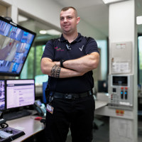 Beveiliger bij de beveiligerspost met de schermen van de beveiliging bij VieCuri