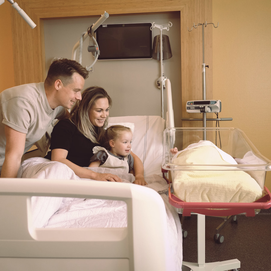 Gezin met pasgeboren baby in bed in Geboortecentrum Noord-Limburg Gezin met pasgeboren baby in bed in Geboortecentrum Noord-Limburg
