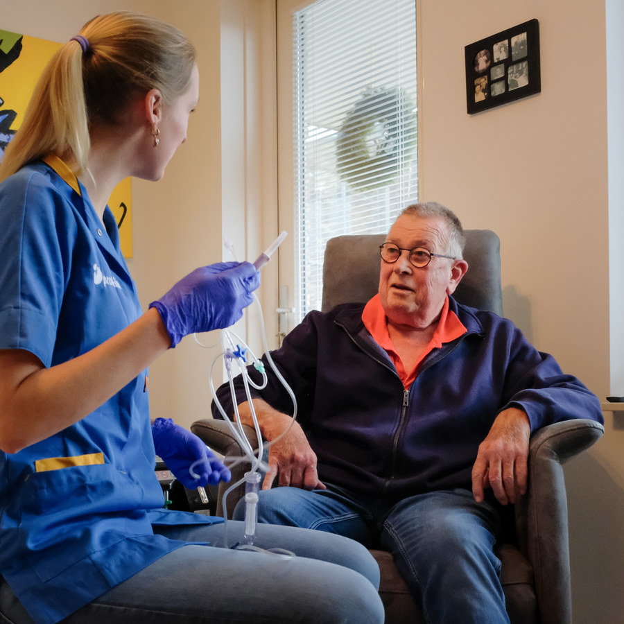 Thuiszorg verpleegkundige Lian Greijn maakt een infuus klaar voor Jan Greijn