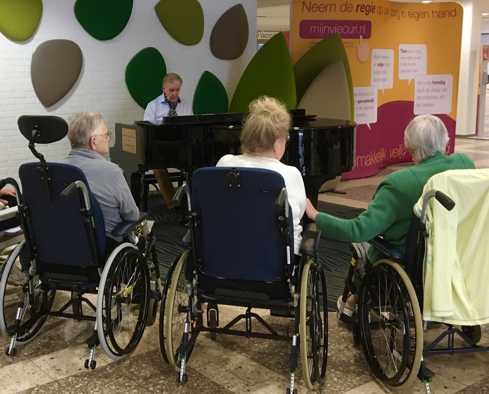 John Janzen achter de piano spelen voor patiënten met de week van de dementie