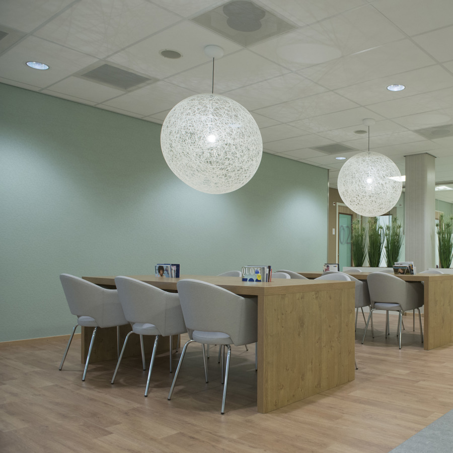 Een wachtkamer met tafels en stoelen Een wachtkamer met tafels en stoelen
