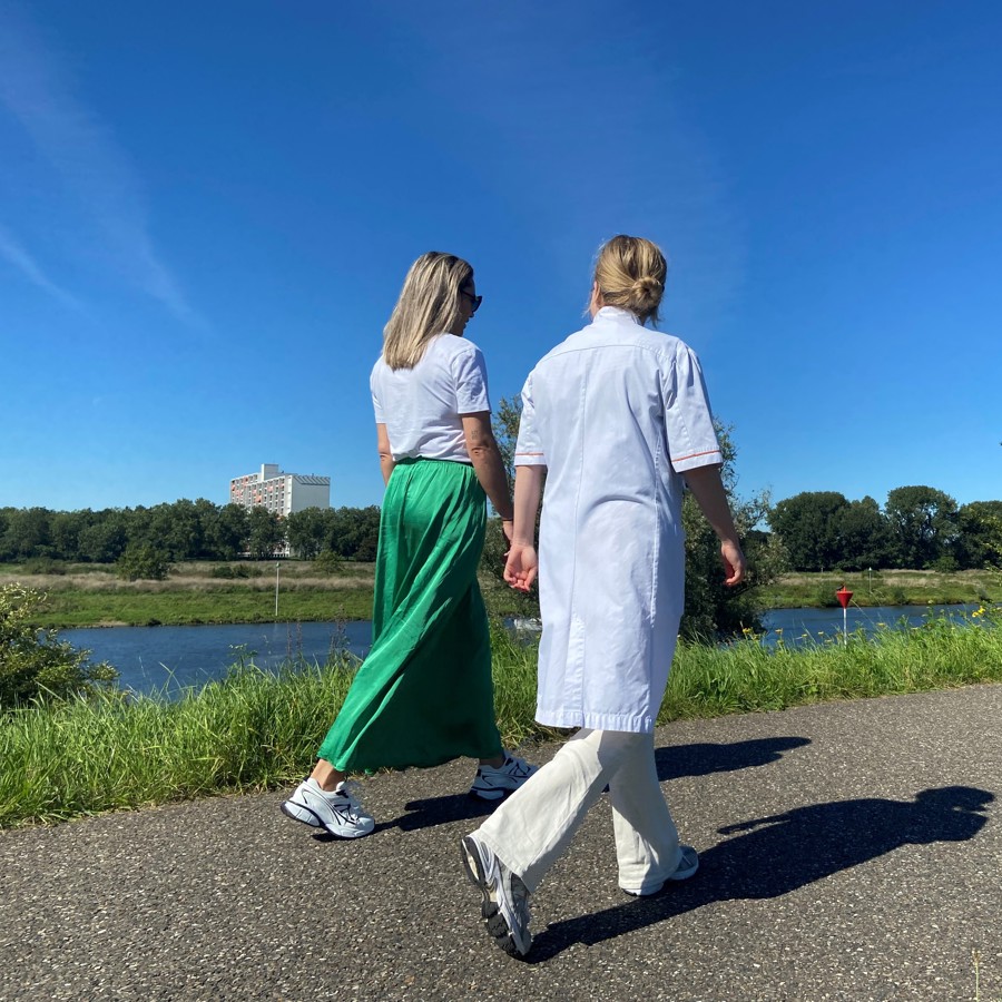 Zorgverlener wandelt met patient Zorgverlener wandelt met patient