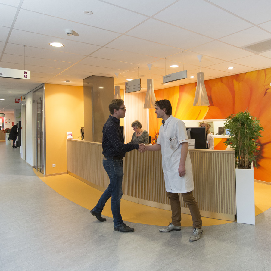 arts verwelkomt patiënt in de wachtkamer arts verwelkomt patiënt in de wachtkamer