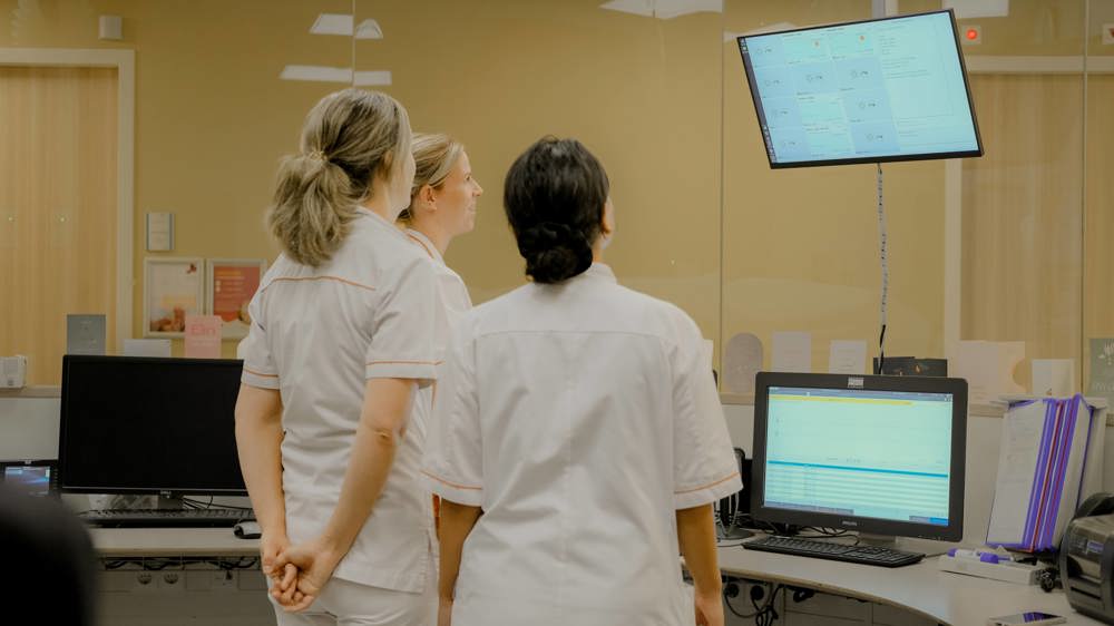 Verpleegkundigen in de verpleegpost op afdeling Neonatologie/ Couveusesuite, kijken op scherm.