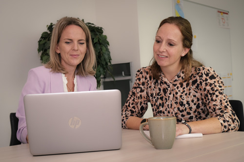 Marielle Stevens en Sanne Joosten in gesprek achter een laptop