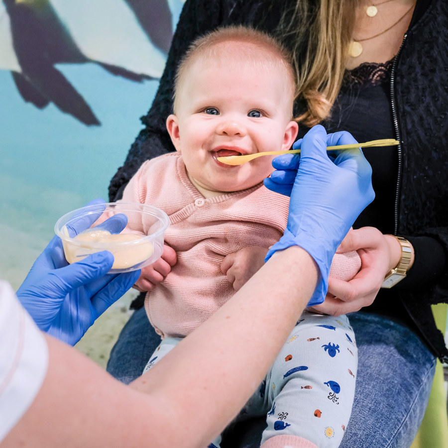 Op deze afbeelding is een baby te zien die bepaald eten als test krijgt. Op deze afbeelding is een baby te zien die bepaald eten als test krijgt.